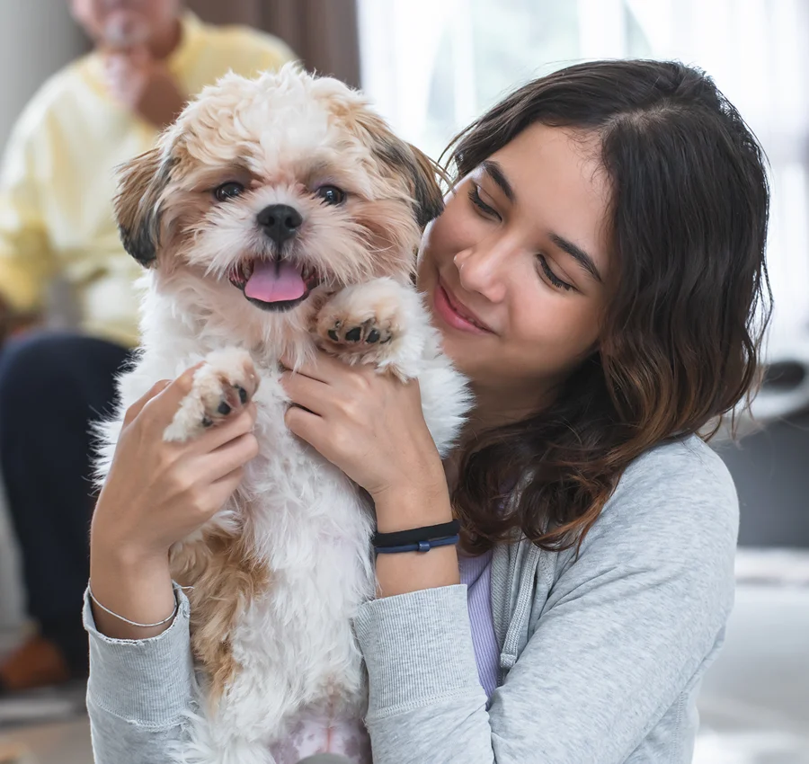 A woman holding a small dog