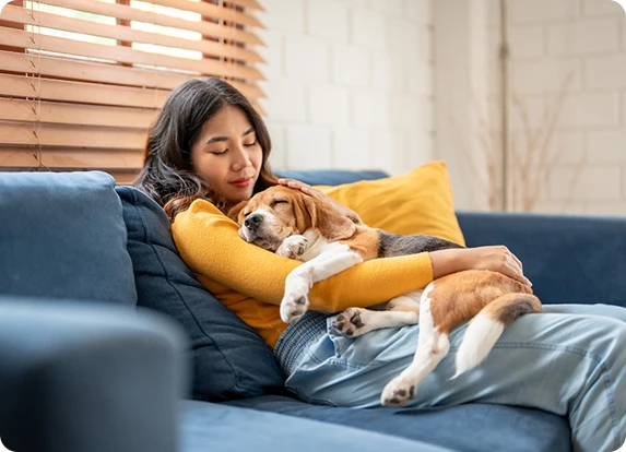 A woman hugging her dog on the couch