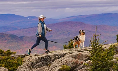 Woman walking her dog in the mountains